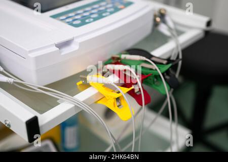 Le médecin cardiologue effectue une procédure d'électrocardiographie sur un homme allongé sur un lit à l'hôpital.Test ECG d'un homme dans une clinique moderne.Diagnostic, voiture saine Banque D'Images