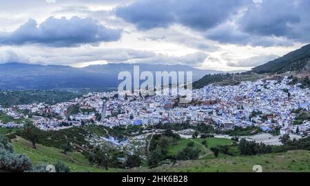 Vue panoramique sur toute la ville de Chefchaouen avec ses bâtiments peints en bleu et blanc, entourés de collines Banque D'Images