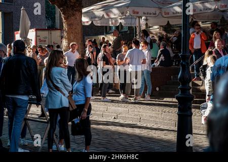 Les visiteurs de l'Altstadt boivent de la bière dans la section extérieure de la brasserie Uerige à Düsseldorf, en Allemagne Banque D'Images