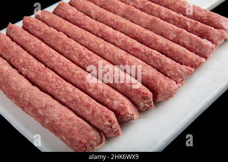 Cuisine turque Tekirdag ou inegol Meatballs.Divers boulettes de bœuf épicées faites maison kofta cru, boulettes de bœuf cru faites sur fond noir. Banque D'Images