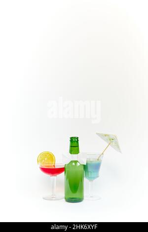 Ensemble de bouteille de bière en verre vert vide avec deux gobelets en verre transparent sur fond blanc.CopySpace.Photographie verticale. Banque D'Images