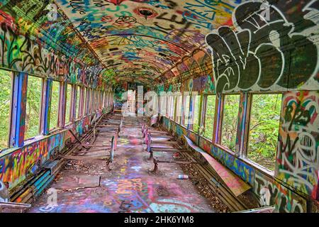 À l'intérieur d'un wagon abandonné avec des graffitis aux couleurs vives. Prise sur un angle pour l'effet. Banque D'Images