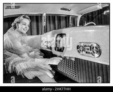 Vintage 1955 Cadillac Westchester voiture intérieure de luxe avec téléphone, magnétophone et TV automobile 14' salon de voiture, avec modèle féminin démontrant une vision de l'avenir de l'automobile avec des accessoires de luxe tels que la voiture TV téléphone 14 pouces télévision, un téléphone, magnétophone,Et des panneaux en bois d'or Korina parmi les caractéristiques de luxe insolites de la voiture d'exposition Westchester 1955 de Cadillac Banque D'Images