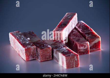 Coupes rectangulaires de bœuf surgelé sur fond sombre Banque D'Images