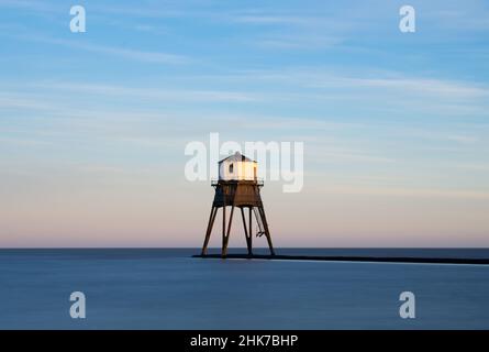 Le soleil couchant illumine le phare victorien Dovercourt Low.Technique d'exposition longue utilisée pour lisser l'eau.Harwich & Dovercourt, Essex, Royaume-Uni Banque D'Images