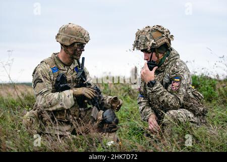 Yavoriv, Ukraine.2nd févr. 2022.Un parachutiste de l'armée américaine affecté au 1st Bataillon, 503rd Parachute Infantry Regiment coordonne l'établissement d'une posture de sécurité commune sur une zone de chute avec un parachutiste de la Brigade lituanienne - polonaise - ukrainienne après avoir mené une opération aéroportée conjointe.Cette formation s'inscrit dans le cadre de l'exercice Rapid Trident 21 du Centre international de sécurité pour le maintien de la paix.(CR Banque D'Images