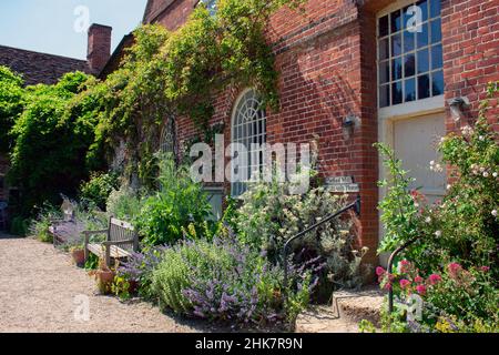 Un sentier avec plantation et bancs en bois à l'extérieur de Flatford Mill et du Miller's Cottage, exploité par le National Trust à Suffolk, en Angleterre. Banque D'Images