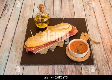 assembler le sandwich dans la poêle avec l'huile, mettre la tomate tranchée avec une pincée de sel, on met le jambon serrano et le fromage Banque D'Images