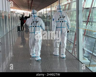 Pékin, Chine.2nd févr. 2022.Des fonctionnaires avec des costumes de matières dangereuses escortent les passagers arrivant à l'aéroport de Pékin (Credit image: © Walter G. Arce Sr./ZUMA Press Wire) Banque D'Images