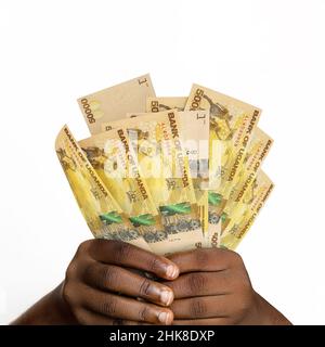 Main noire tenant 3D a rendu 50000 notes de shilling ougandaises. gros plan des mains tenant des notes de monnaie ougandaises Banque D'Images