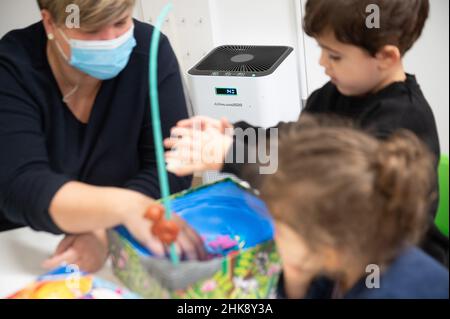 Darmstadt, Allemagne.02nd févr. 2022.Un appareil de purification de l'air se tient derrière un éducateur et des enfants dans une garderie.L'Association des parents de Hesse réclame des règles de quarantaine uniformes dans les garderies de tout l'État.Credit: Sebastian Gollnow/dpa/Alay Live News Banque D'Images