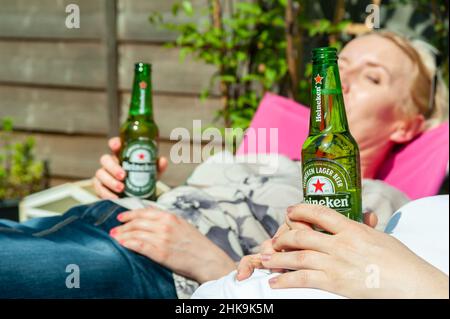 22.04.2019. Londres, Royaume-Uni. Un groupe d'amis ayant une bière en bouteille Heineken dans le jardin Banque D'Images