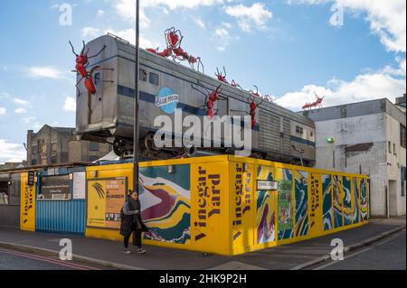 Le restaurant en plein air de vinaigre Yard propose des vendeurs de nourriture, des bars servant de la bière locale, un marché aux puces et des boutiques. Installation d'art de train par Joe Rush. Banque D'Images