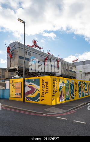 Le restaurant en plein air de vinaigre Yard propose des vendeurs de nourriture, des bars servant de la bière locale, un marché aux puces et des boutiques. Installation d'art de train par Joe Rush. Banque D'Images