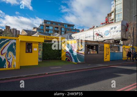 Le restaurant en plein air de vinaigre Yard propose des vendeurs de nourriture, des bars servant de la bière locale, un marché aux puces et des boutiques. Installation d'art de train par Joe Rush. Banque D'Images