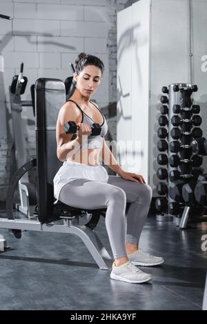 Moyen-Orient sportswoman s'entraîner avec haltères dans la salle de gym Banque D'Images