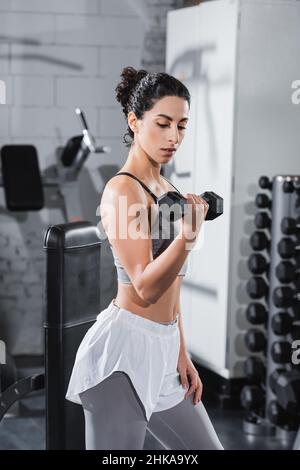 Moyen-Orient sportswoman s'entraîner avec haltères dans la salle de gym Banque D'Images