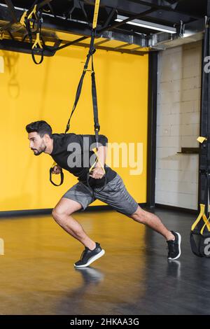 Entraînement sportif arabe sportif avec sangles de suspension dans le centre sportif Banque D'Images