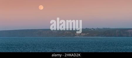 Image panoramique d'une pleine lune au-dessus de Watergate et de Watergate Bay sur la côte nord de Cornwall. Banque D'Images