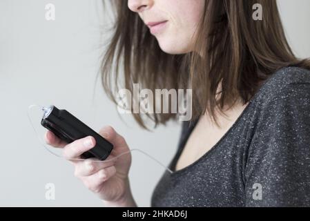 Une femme tenant une pompe à insuline Banque D'Images