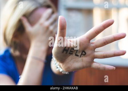 Femme gestante aide signe sur sa main.Concept de dépression Banque D'Images