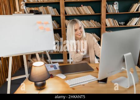 Une jeune femme adulte ayant une visioconférence avec ses collègues, montre les grandes idées pour le projet. Belle femme d'affaires utilisant Banque D'Images