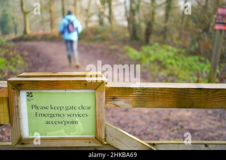 Panneau poli dans les bois du National Trust UK rappelant aux marcheurs et aux randonneurs « Veuillez garder la porte à l'écart, services d'urgence - point d'accès ». Banque D'Images