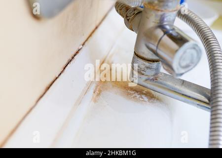 Vieux lavabo sale avec taches de rouille, de calcaire et de savon dans la salle de bains avec un robinet, un robinet d'eau. Banque D'Images