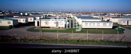 Rangée après rangée de caravanes dans le site de caravane dans Lydd Road, près de Camber Sands.En arrière-plan est le parc éolien Little Cheyne court. Banque D'Images