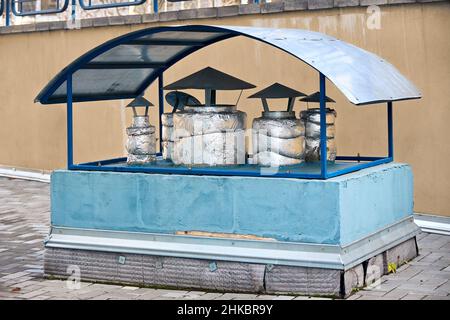 Système de ventilation d'échappement de toit d'air d'un bâtiment commercial avec une feuille à capuchon isolant thermique cheminées et conduits regroupés sous le capot Banque D'Images