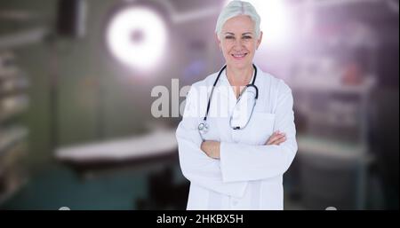 Confiante souriante caucasienne femme mature médecin avec les bras croisés debout dans le théâtre d'opération Banque D'Images