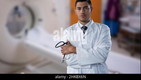 Portrait d'un médecin biracial professionnel avec bras croisés debout contre un scanner irm Banque D'Images
