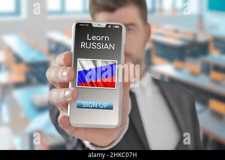 Concept en ligne Apprenez la langue russe avec une personne montrant l'application e-learning sur téléphone mobile avec le drapeau de la Russie Banque D'Images