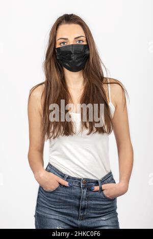 Soins de santé, Covid-19, concept de médecine.Portrait d'une jeune et belle femme brune debout avec de longs poils et des yeux bleus portant de la médecine noire Banque D'Images