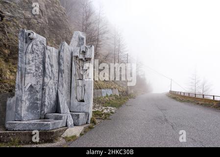 Route de montagne à Alpi Apuane, Italie, œuvres d'art en marbre/monument sur le côté de la route et route nuageux devant vous. Banque D'Images