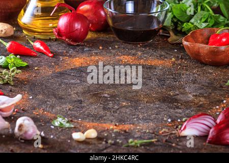 Cuisine de fond avec surface en pierre de cuisine, huile d'olive dans une carafe et légumes.Espace vide pour le menu ou la recette avec mise au point sélective Banque D'Images
