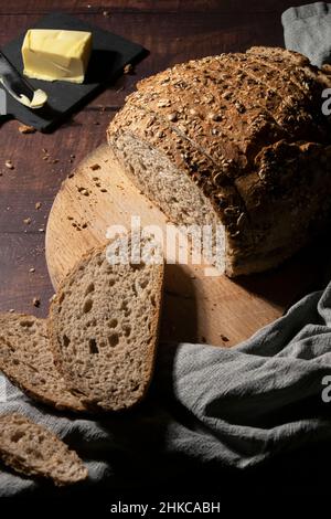 Tranches de pain complet au beurre sur une table en bois rustique Banque D'Images