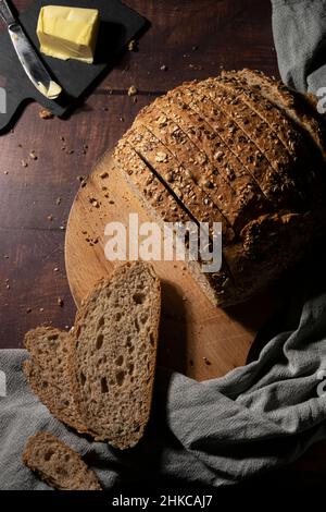 Tranches de pain complet au beurre sur une table en bois rustique Banque D'Images