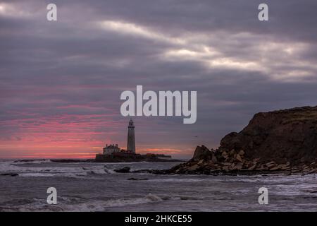 Un lever de soleil spectaculaire au phare de St Mary's à Whitley Bay, alors que le ciel éclate en couleur Banque D'Images