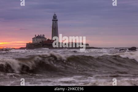 Un lever de soleil spectaculaire au phare de St Mary's à Whitley Bay, alors que le ciel éclate en couleur Banque D'Images