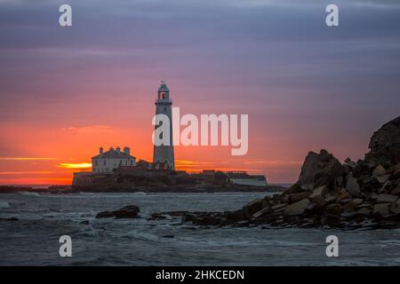 Un lever de soleil spectaculaire au phare de St Mary's à Whitley Bay, alors que le ciel éclate en couleur Banque D'Images