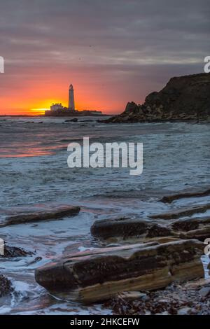 Un lever de soleil spectaculaire au phare de St Mary's à Whitley Bay, alors que le ciel éclate en couleur Banque D'Images