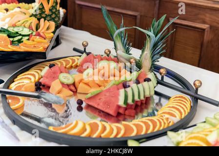 Des tranches de pastèque, de kiwis, de mangue et d'orange constituent une exposition décorative sur la table du buffet pour les invités de la fête. Banque D'Images