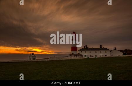 Le rouge et blanc rayé, 23 mètres de haut, le phare de Souter et les Leas à Marsden, South Shields, Angleterre, comme le soleil se lève Banque D'Images