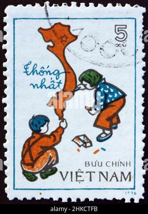 VIETNAM - VERS 1977 : un timbre imprimé au Vietnam montre des enfants dessinant une carte du Vietnam unifié, vers 1977 Banque D'Images