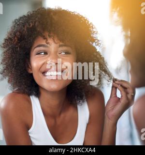 Elle a une belle journée de cheveux.Plan court d'une jeune femme examinant ses cheveux dans la salle de bains. Banque D'Images