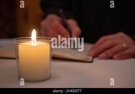 Kusel, Allemagne.03rd févr. 2022.Une femme signe l'un des deux livres de condoléances dans l'église de la ville avant le service commémoratif œcuménique des deux policiers tués dans la nuit de lundi (Jan31, 2022).Un inspecteur en chef de 29 ans et son collègue de 24 ans, un stagiaire de police, avaient été abattus tôt lundi matin lors d'une vérification de véhicule.Credit: Harald Tittel/dpa/Alay Live News Banque D'Images