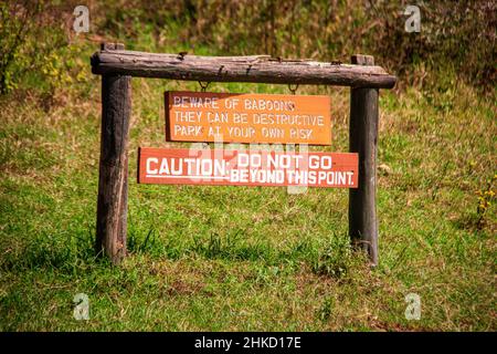 Vue d'un panneau 'attention des babouins, ils peuvent être destructeurs, ne pas aller au-delà de ce point' à l'entrée du parc national du lac Nakuru, Kenya Banque D'Images