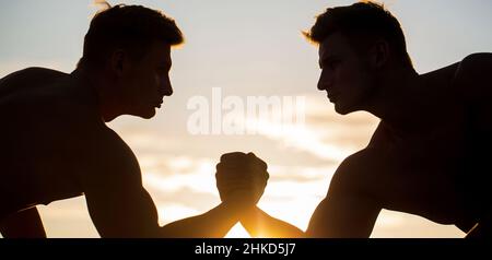 Silhouette de mains qui rivalisent en force. Rivalité, gros plan de lutte de bras mâle. Hommes mesurant les forces, les bras. Deux hommes lutte bras. Rivalité, vs Banque D'Images