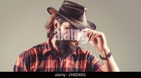 Cow-boys non rasés. Cow-boy américain. Chapeau de cowboy en cuir. Portrait d'un jeune homme portant un chapeau de cow-boy. Cowboys en chapeau. Jolie macho barbu Banque D'Images